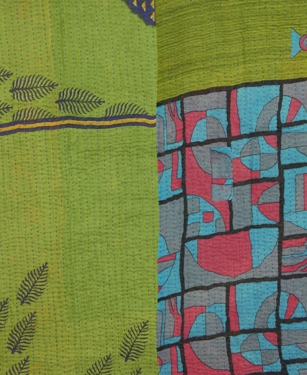 kantha quilt throw with a tag featuring the hand-stitched signature of the maker