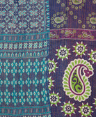 kantha quilt throw with a tag featuring the hand-stitched signature of the maker