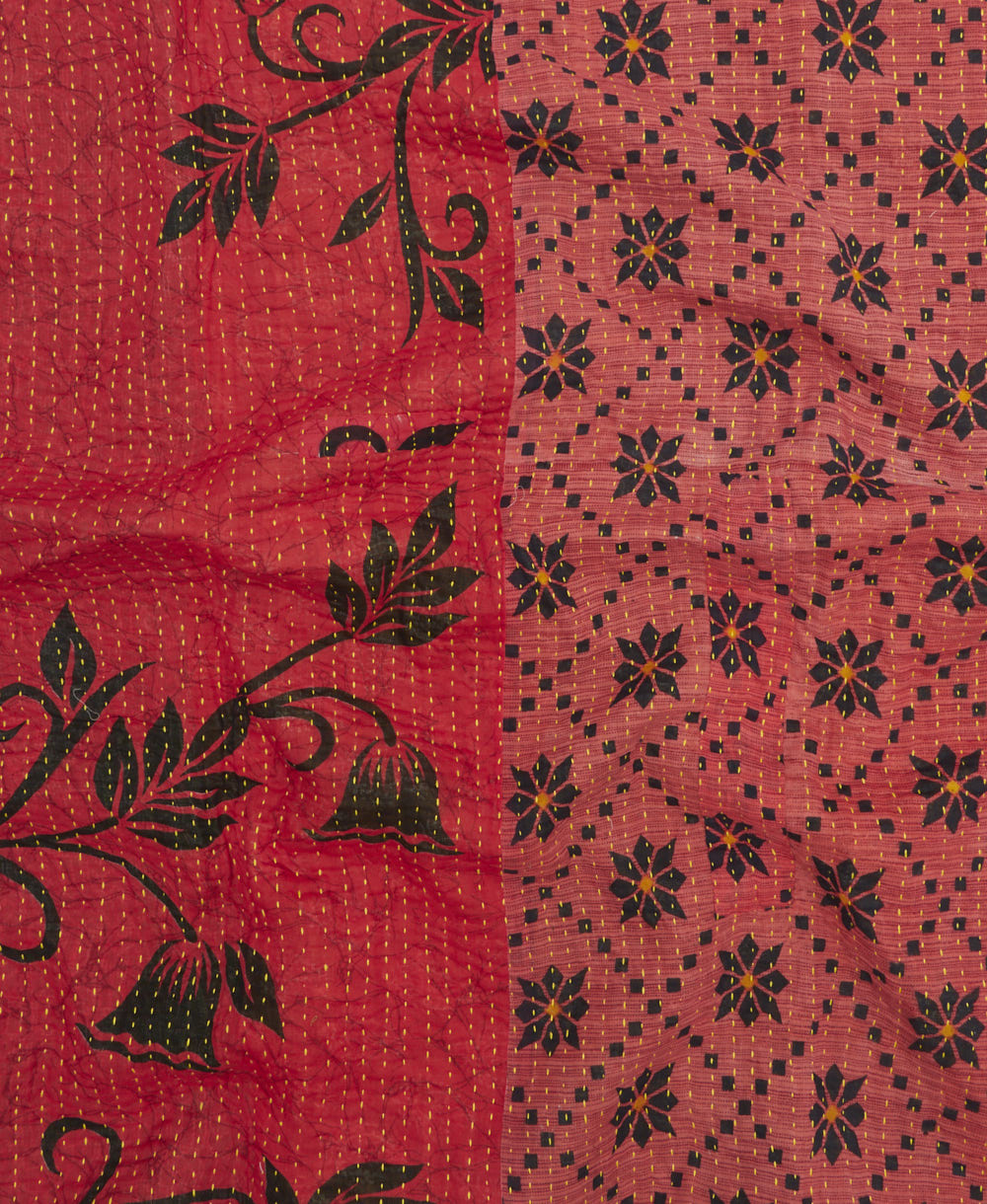 kantha quilt throw with a tag featuring the hand-stitched signature of the maker
