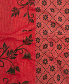 kantha quilt throw with a tag featuring the hand-stitched signature of the maker