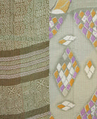 kantha quilt throw with a tag featuring the hand-stitched signature of the maker