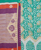 kantha quilt throw with a tag featuring the hand-stitched signature of the maker