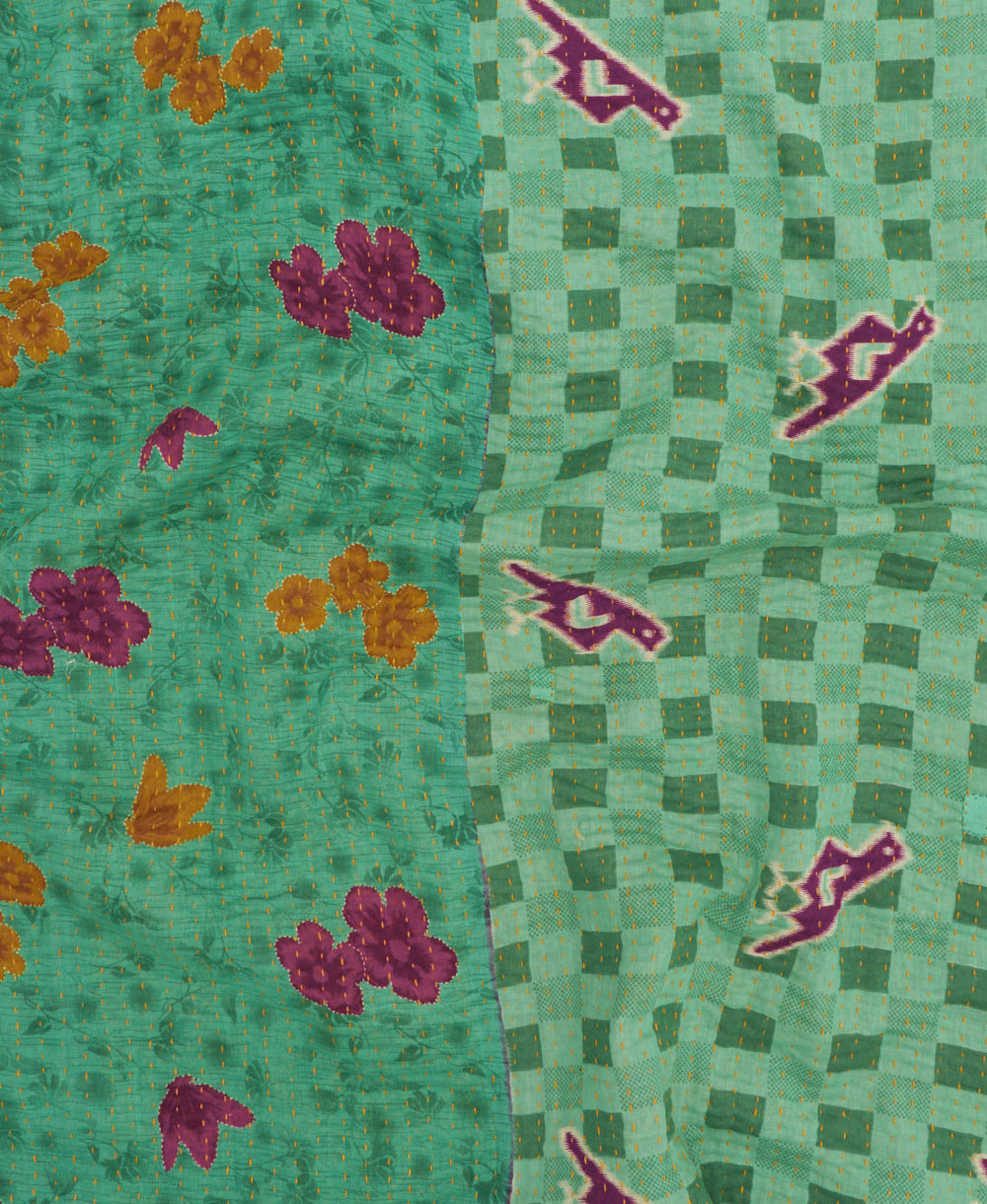 kantha quilt throw with a tag featuring the hand-stitched signature of the maker