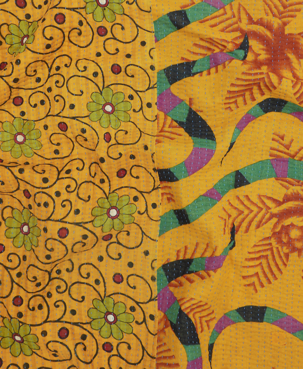 kantha quilt throw with a tag featuring the hand-stitched signature of the maker