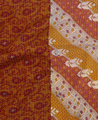 kantha quilt throw with a tag featuring the hand-stitched signature of the maker