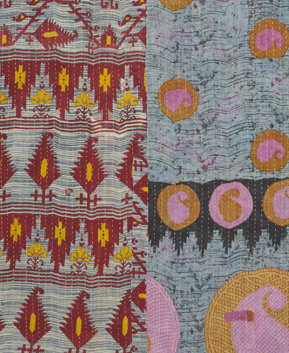 kantha quilt throw with a tag featuring the hand-stitched signature of the maker