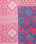 kantha quilt throw with a tag featuring the hand-stitched signature of the maker