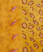 kantha quilt throw with a tag featuring the hand-stitched signature of the maker