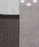 kantha quilt throw with a tag featuring the hand-stitched signature of the maker