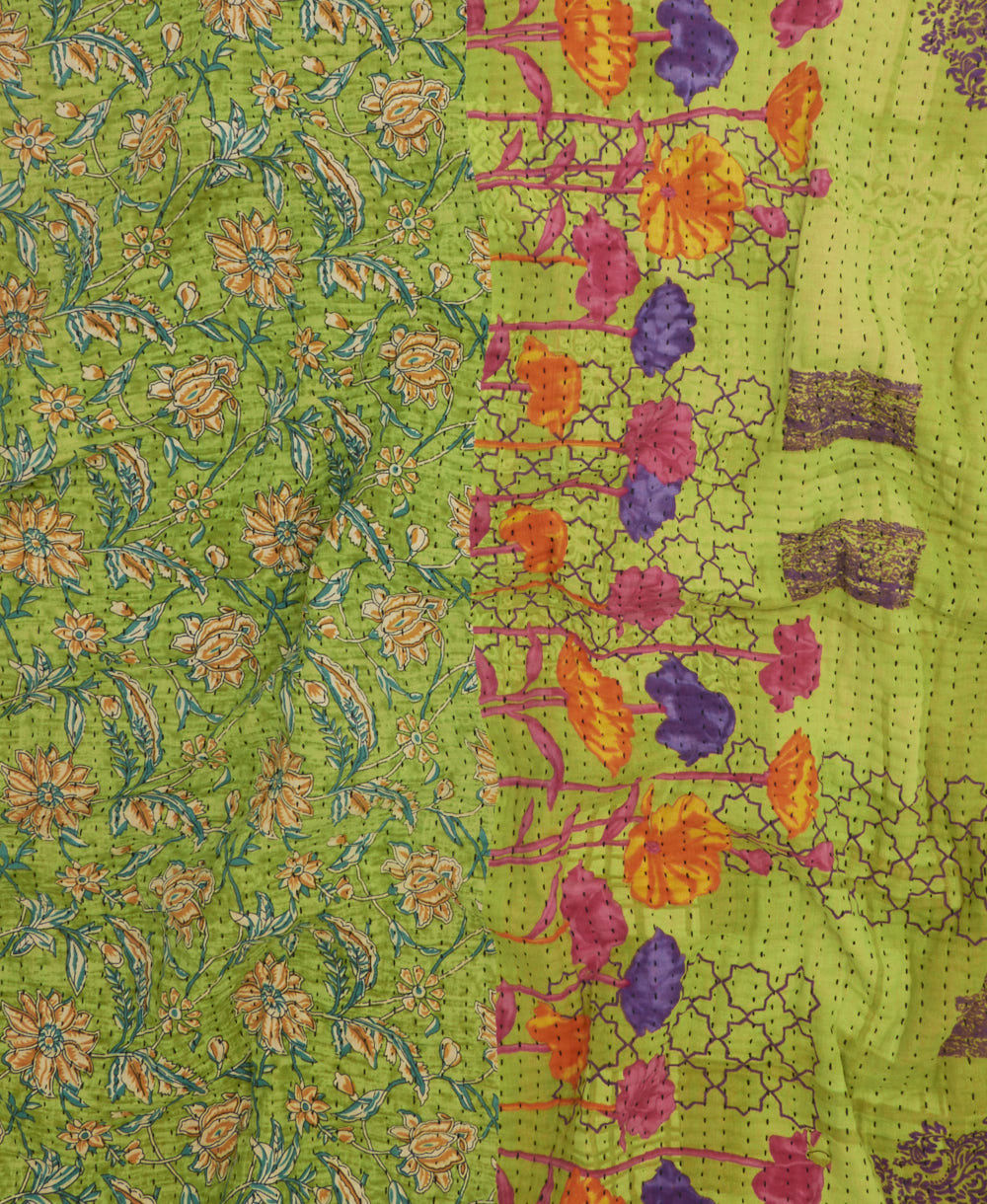 kantha quilt throw with a tag featuring the hand-stitched signature of the maker