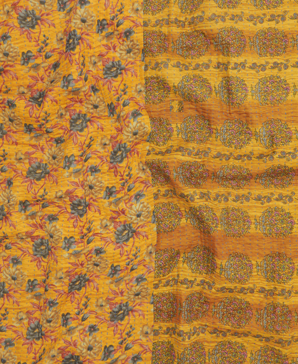 kantha quilt throw with a tag featuring the hand-stitched signature of the maker