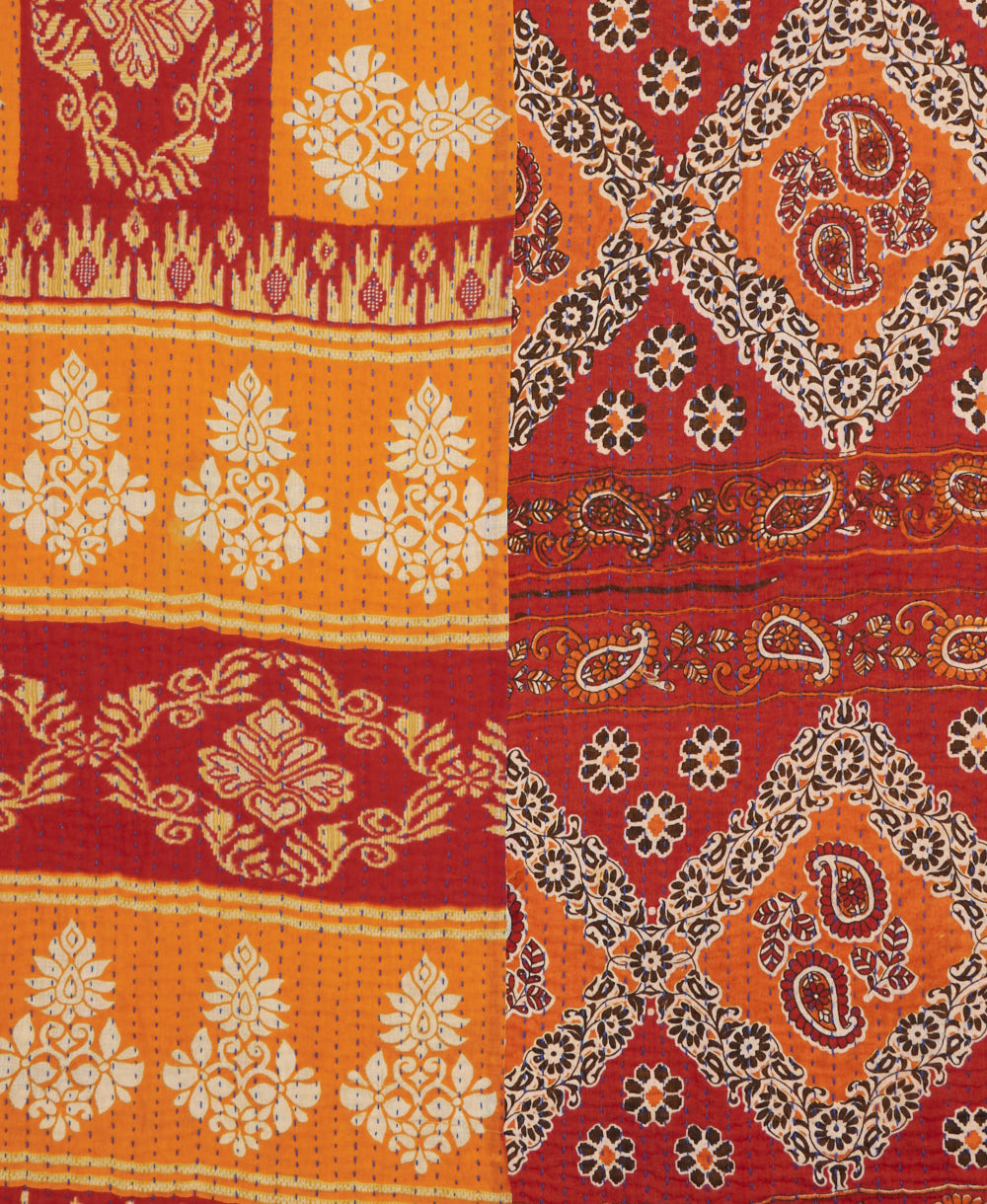kantha quilt throw with a tag featuring the hand-stitched signature of the maker