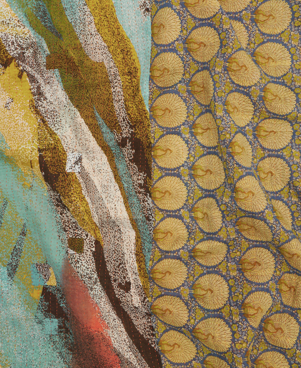kantha quilt throw with a tag featuring the hand-stitched signature of the maker
