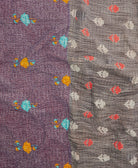 kantha quilt throw with a tag featuring the hand-stitched signature of the maker