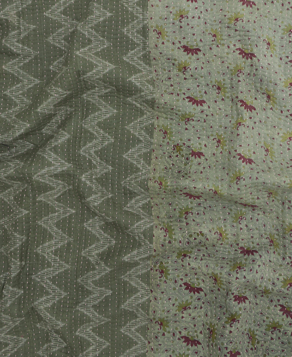 kantha quilt throw with a tag featuring the hand-stitched signature of the maker