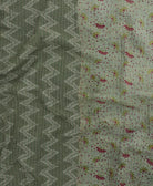 kantha quilt throw with a tag featuring the hand-stitched signature of the maker