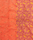 kantha quilt throw with a tag featuring the hand-stitched signature of the maker