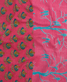kantha quilt throw with a tag featuring the hand-stitched signature of the maker