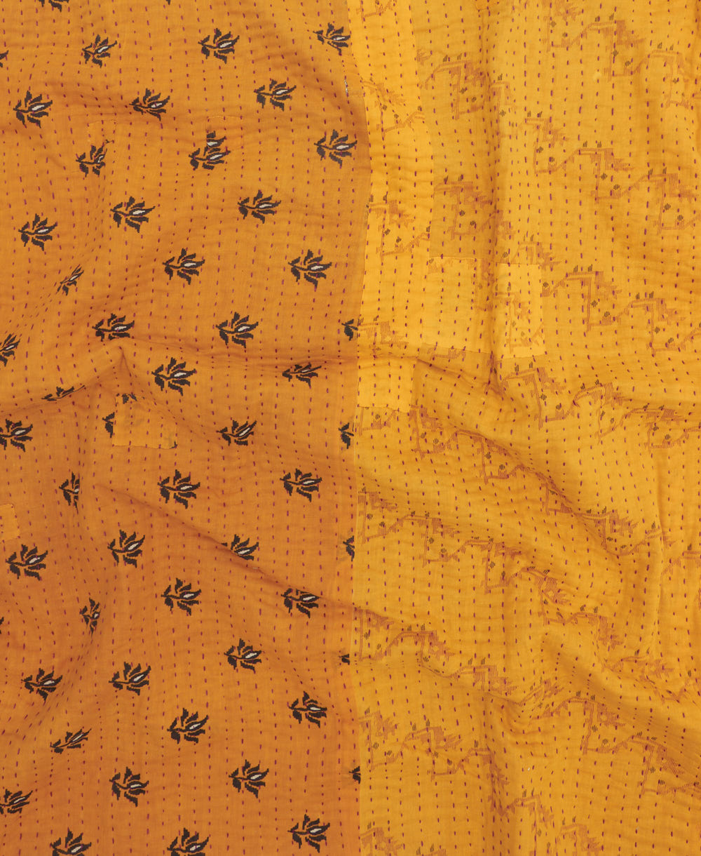 kantha quilt throw with a tag featuring the hand-stitched signature of the maker