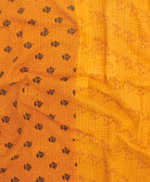 kantha quilt throw with a tag featuring the hand-stitched signature of the maker