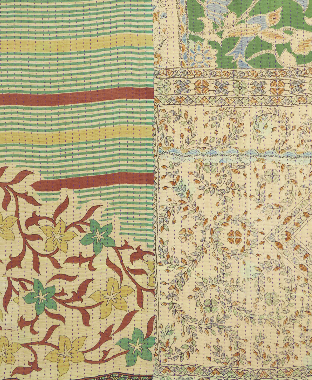 kantha quilt throw with a tag featuring the hand-stitched signature of the maker
