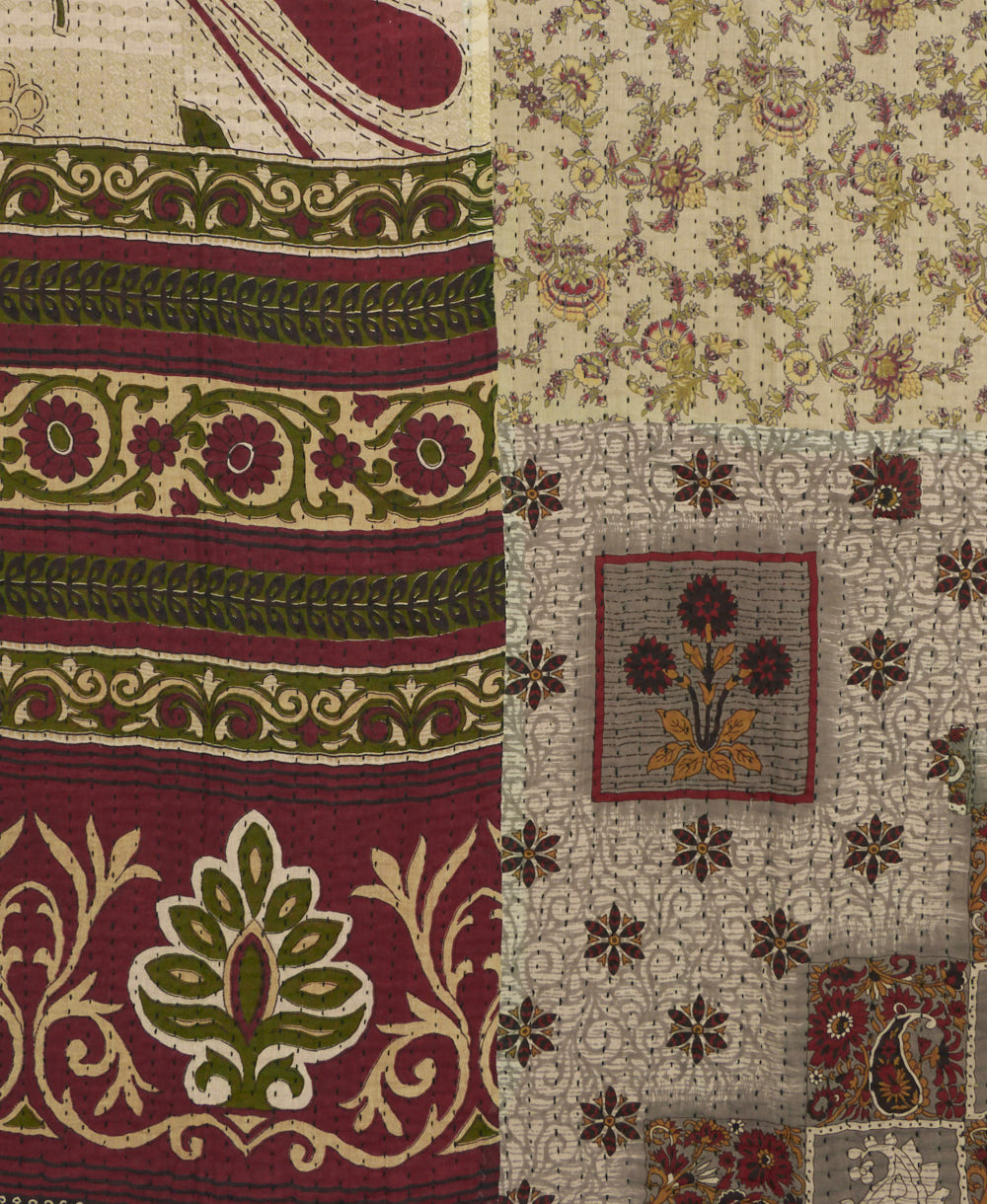kantha quilt throw with a tag featuring the hand-stitched signature of the maker