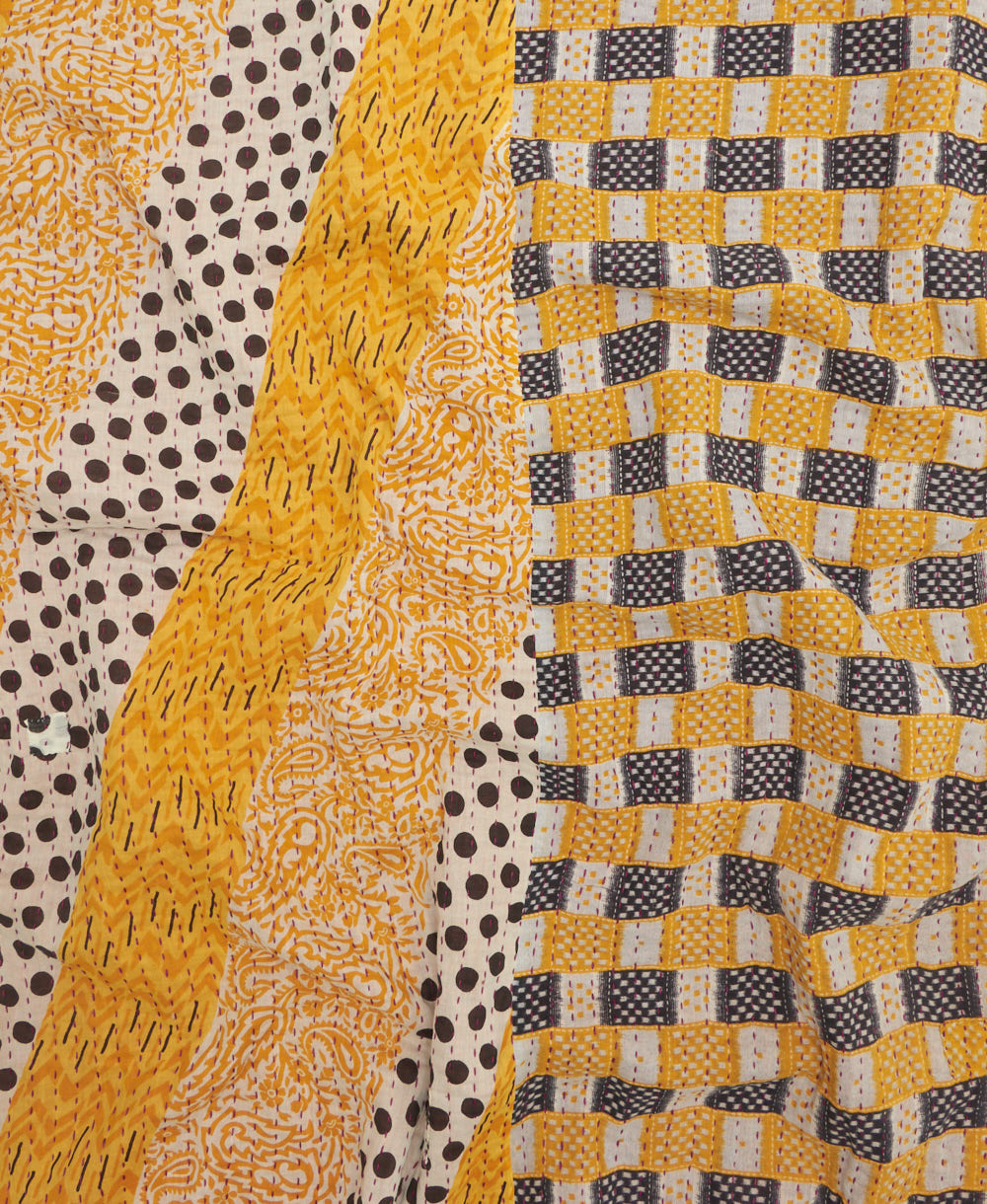 kantha quilt throw with a tag featuring the hand-stitched signature of the maker