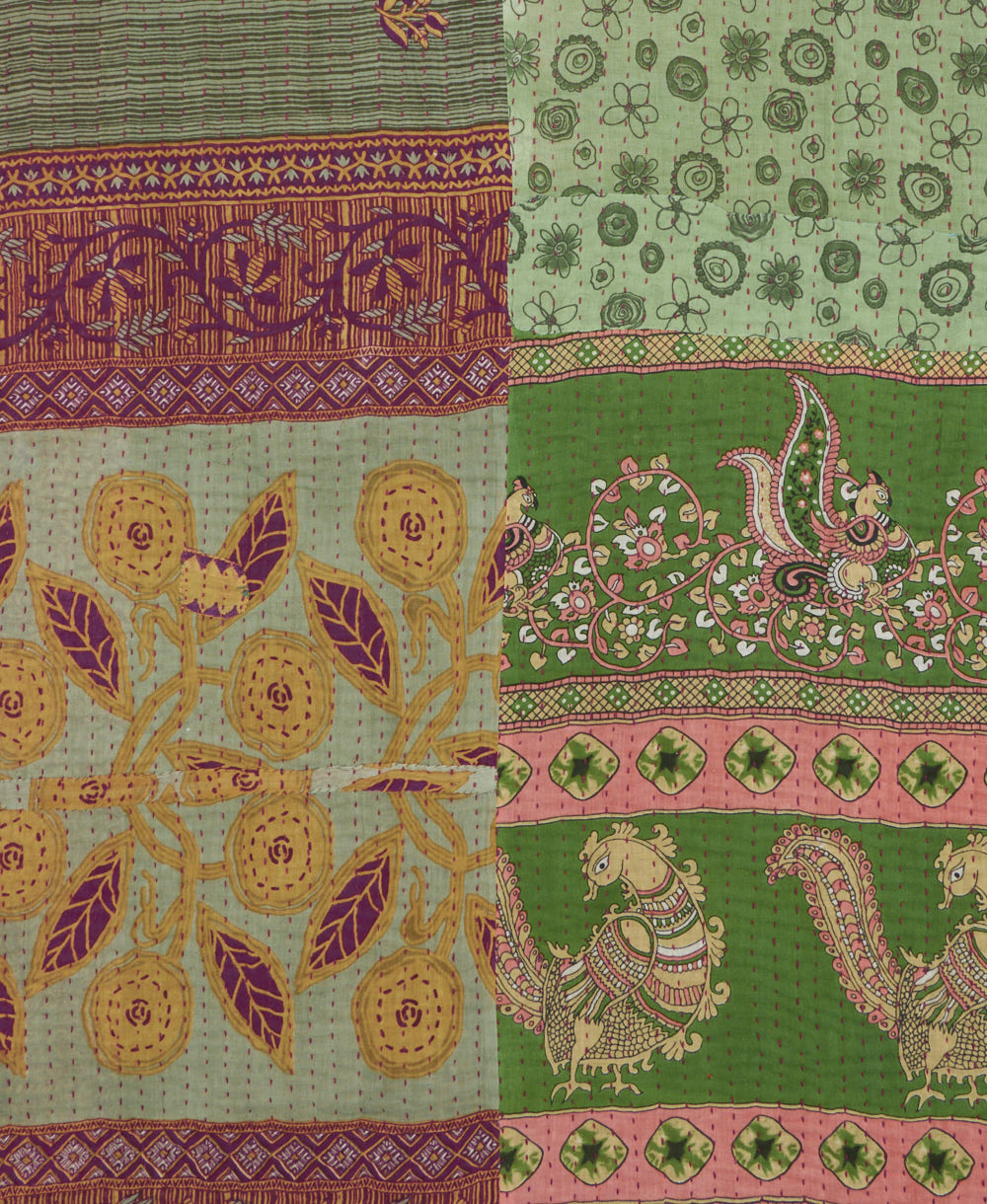 kantha quilt throw with a tag featuring the hand-stitched signature of the maker