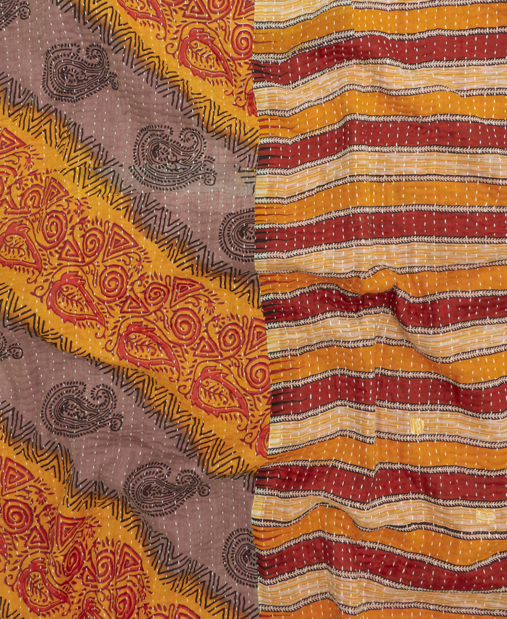 kantha quilt throw with a tag featuring the hand-stitched signature of the maker