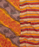 kantha quilt throw with a tag featuring the hand-stitched signature of the maker