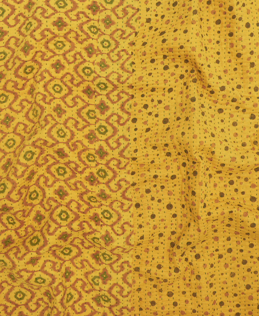 kantha quilt throw with a tag featuring the hand-stitched signature of the maker