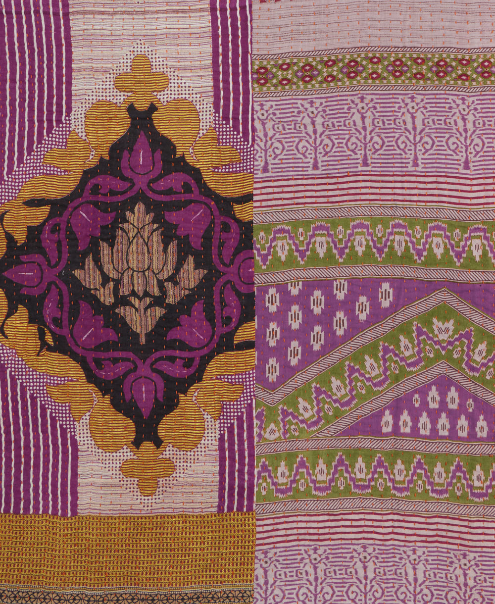 kantha quilt throw with a tag featuring the hand-stitched signature of the maker