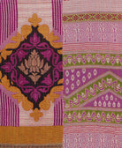 kantha quilt throw with a tag featuring the hand-stitched signature of the maker