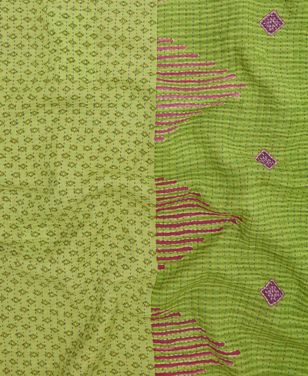 kantha quilt throw with a tag featuring the hand-stitched signature of the maker