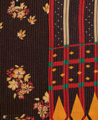 kantha quilt throw with a tag featuring the hand-stitched signature of the maker