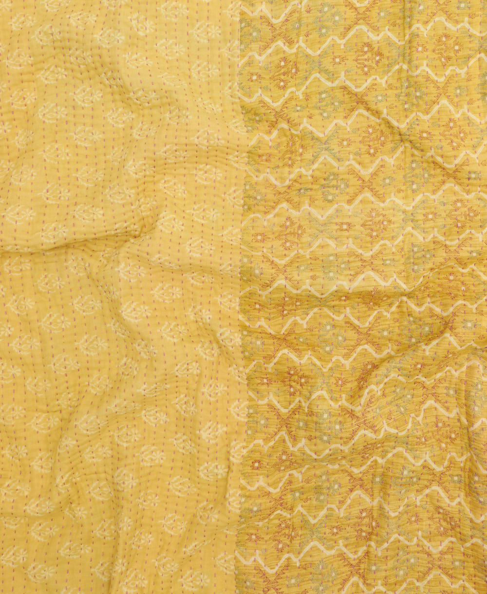 kantha quilt throw with a tag featuring the hand-stitched signature of the maker