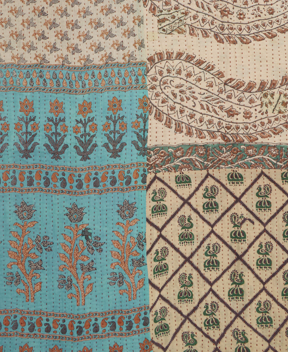kantha quilt throw with a tag featuring the hand-stitched signature of the maker