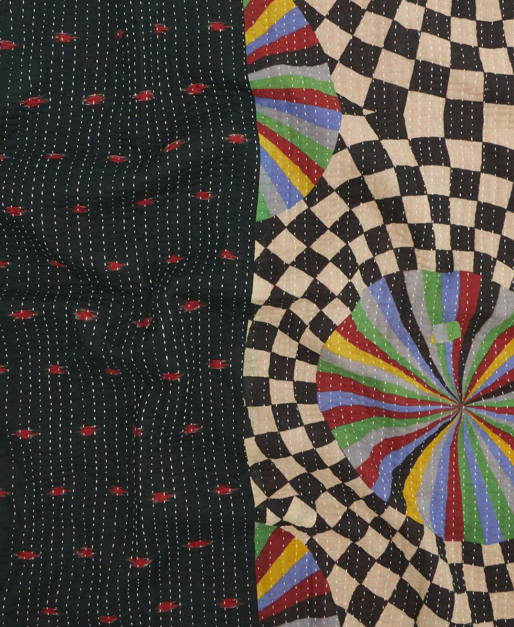 kantha quilt throw with a tag featuring the hand-stitched signature of the maker