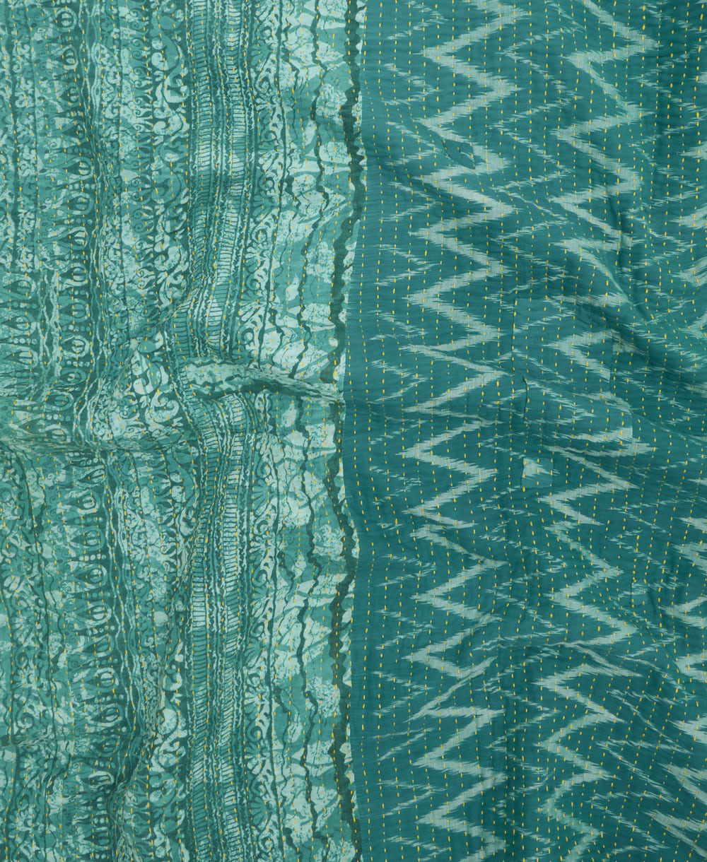 kantha quilt throw with a tag featuring the hand-stitched signature of the maker