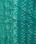 kantha quilt throw with a tag featuring the hand-stitched signature of the maker