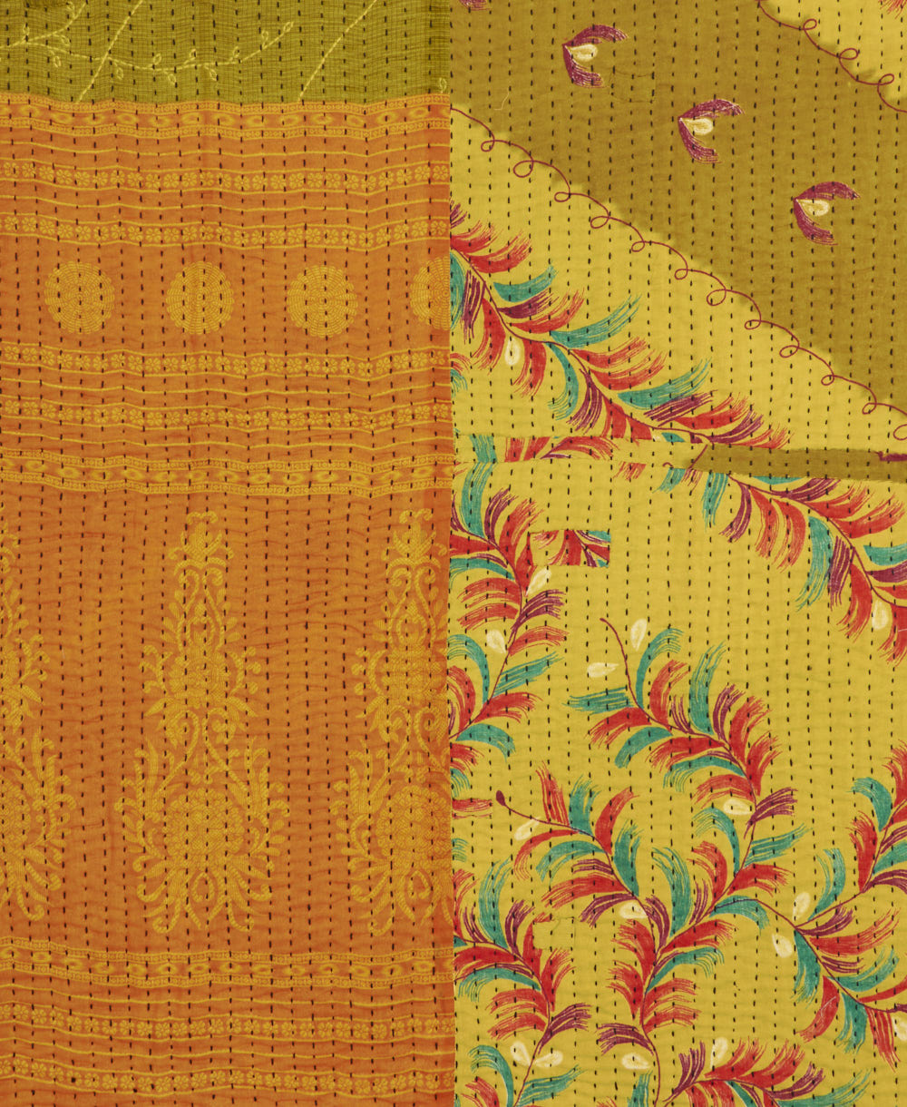 kantha quilt throw with a tag featuring the hand-stitched signature of the maker