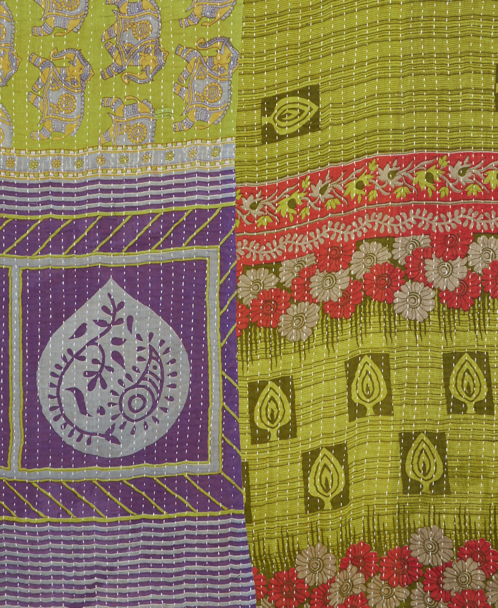 kantha quilt throw with a tag featuring the hand-stitched signature of the maker