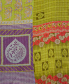 kantha quilt throw with a tag featuring the hand-stitched signature of the maker