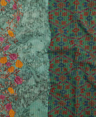 kantha quilt throw with a tag featuring the hand-stitched signature of the maker