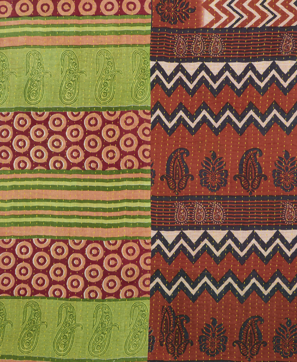 kantha quilt throw with a tag featuring the hand-stitched signature of the maker