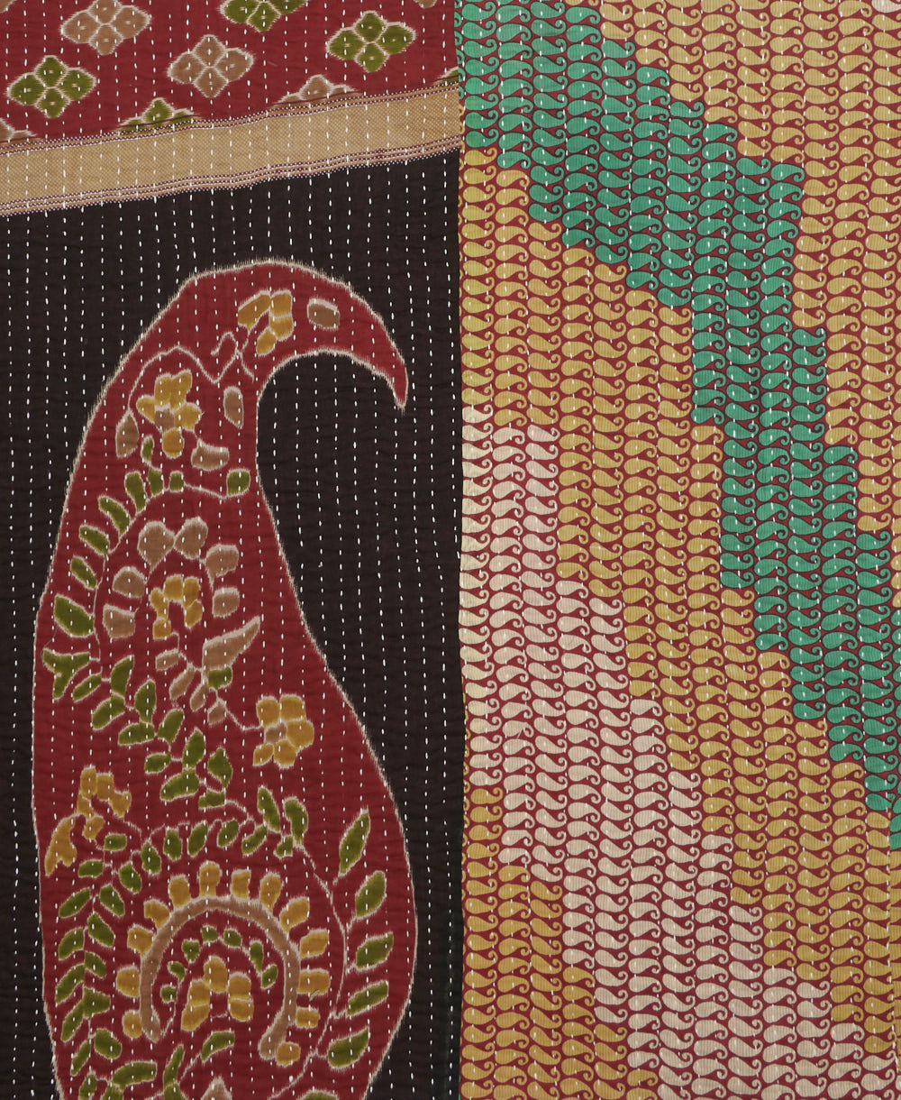 kantha quilt throw with a tag featuring the hand-stitched signature of the maker