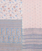 kantha quilt throw with a tag featuring the hand-stitched signature of the maker