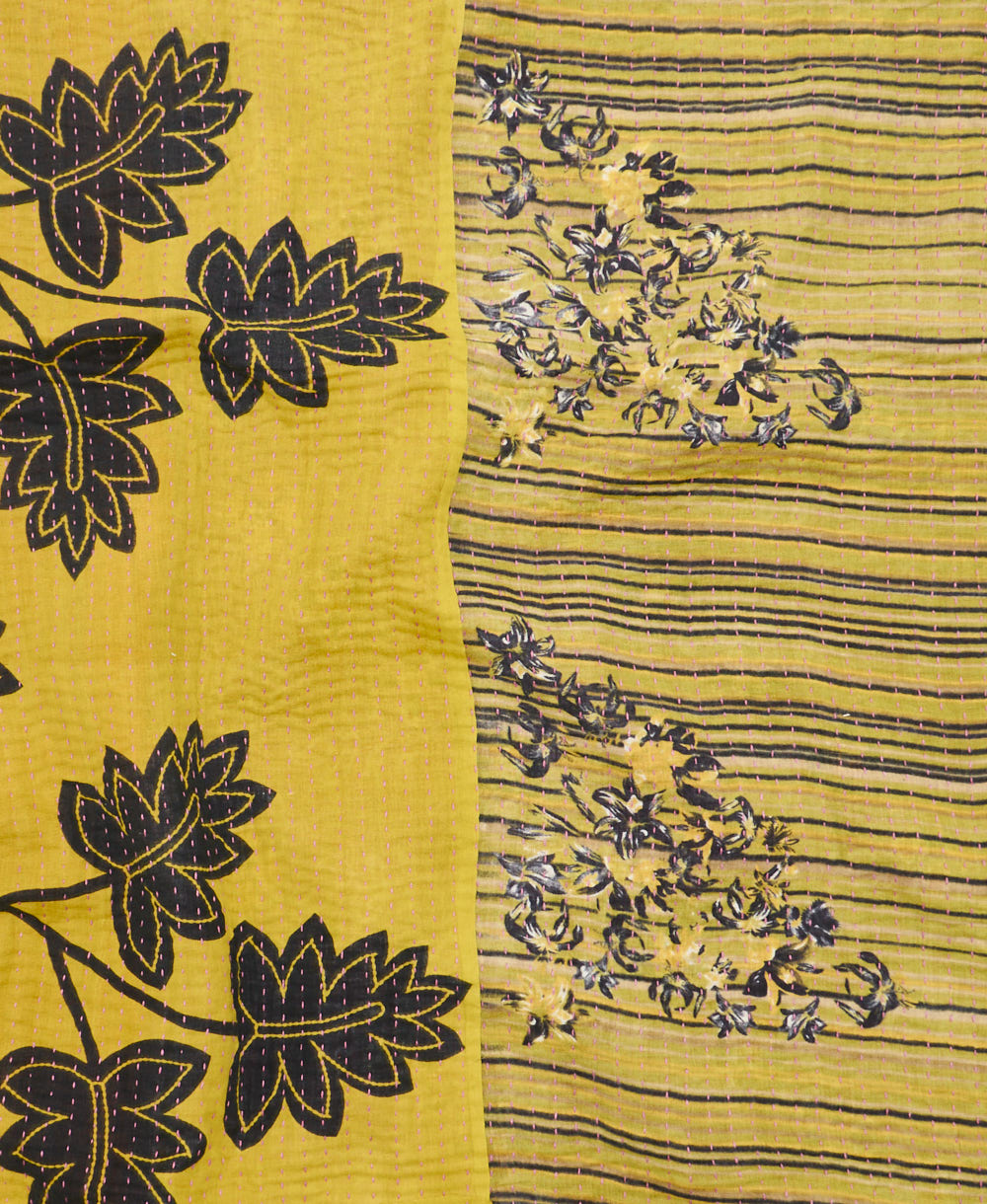 kantha quilt throw with a tag featuring the hand-stitched signature of the maker