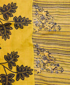 kantha quilt throw with a tag featuring the hand-stitched signature of the maker
