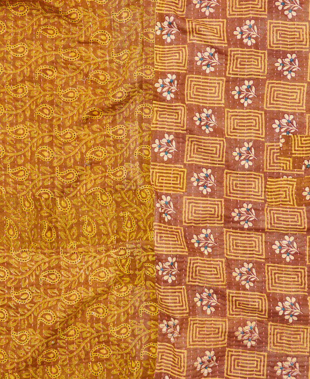 kantha quilt throw with a tag featuring the hand-stitched signature of the maker